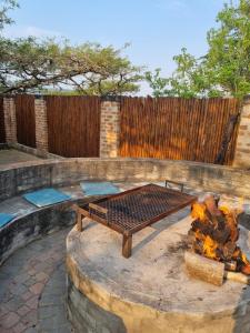 een vuurplaats in de achtertuin met een grill bij Selah Guest Cottages Self-catering Farmstay Accommodation in Nelspruit