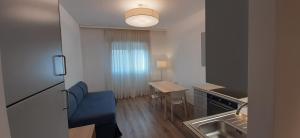 eine kleine Küche mit einem blauen Sofa und einem Tisch in der Unterkunft Delta Hotel Apartments in San Donato Milanese
