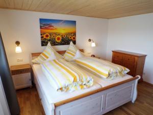 a bedroom with a bed with yellow and white pillows at Landhaus Müller in Bad Birnbach