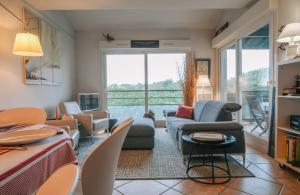 een woonkamer met een bank en een tafel bij Chiberta - entre plages et golf in Anglet