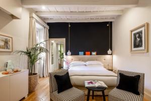 a bedroom with a large bed and two chairs at Nerva Boutique Hotel in Rome