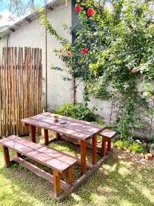 een houten picknicktafel en bank in een tuin bij Selah Guest Cottages Self-catering Farmstay Accommodation in Nelspruit