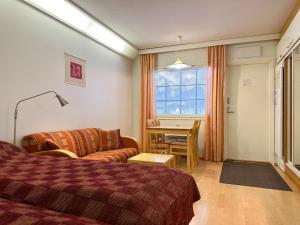 una camera d'albergo con letto, divano e tavolo di Hotel Tahko a Tahkovuori