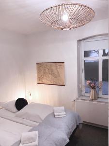 1 dormitorio con 2 camas, ventana y lámpara de araña en Vibæk, en Sønderborg