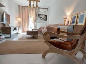 een woonkamer met een bank en een stoel bij Antigonidon Square Luxury Apartment in Thessaloniki