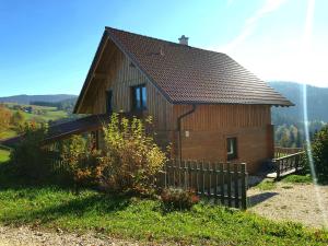 una pequeña casa de madera con una valla delante en Ferienhaus Lärchenhütte en Kasperle