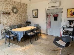 a dining room with a table and some chairs at Mas 19e climatisé avec piscine à usage exclusif in Roquemaure