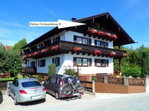 a house with two cars parked in front of it at Landhaus Müller in Bad Birnbach