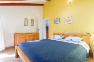 een slaapkamer met een blauw bed en een gele muur bij House Ivo in Stomorska