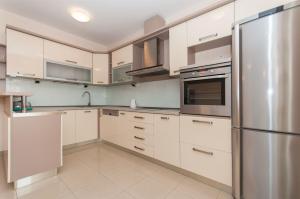 a kitchen with white cabinets and a stainless steel refrigerator at Apartment Temza in Krilo