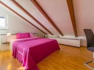 a bedroom with a pink bed in a attic at Apartments Sylvia in Dramalj