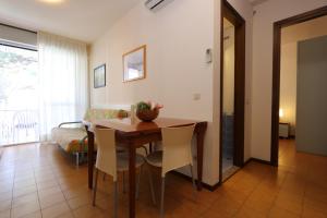 a dining room with a table and chairs and a couch at Appartamenti Erica in Bibione