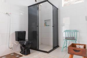 a bathroom with a shower with a toilet and a stool at Suítes em Casa Duplex no Pontal in Ilhéus