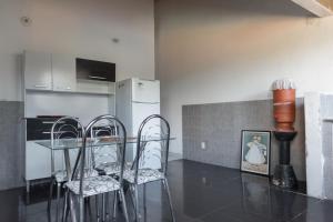 a kitchen with a table with chairs and a refrigerator at Suítes em Casa Duplex no Pontal in Ilhéus