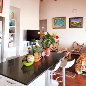 una sala de estar con una mesa con frutas y flores. en Chambre chez l'habitant à L' Amirade chez Michelle, en Grande Anse