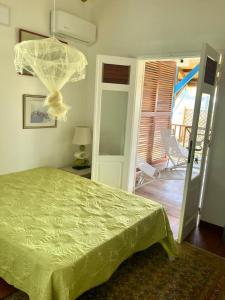 1 dormitorio con 1 cama con colcha verde en Chambre chez l'habitant à L' Amirade chez Michelle, en Grande Anse