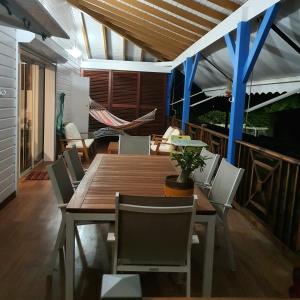 a dining room with a wooden table and chairs at Chambre chez l'habitant à L' Amirade chez Michelle in Grande Anse