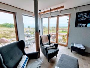 a living room with two chairs and a large window at House of Freedom with Sea View and Sauna in Osłonino