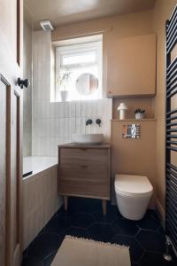 een badkamer met een wastafel, een toilet en een raam bij Relax in Stunning House in Great Central Location in Cardiff