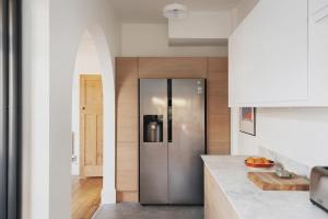 a kitchen with a stainless steel refrigerator in a room at Relax in Stunning House in Great Central Location in Cardiff