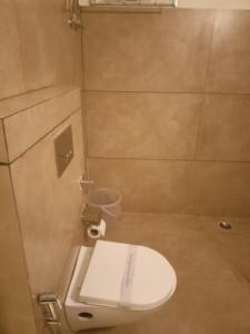 y baño con aseo blanco en una cabina. en Hotel Pearl,Indore en Indore