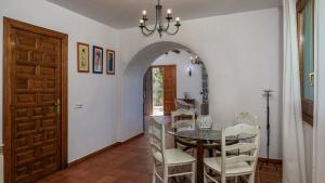 アンテケラにあるAlmendros Antequera - Los Nogales by Ruralidaysのテーブルと白い椅子のあるダイニングルーム