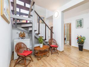 een woonkamer met een tafel, stoelen en een trap bij Villa Ketty in Fažana