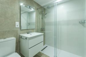 y baño con aseo, lavabo y ducha. en LETS HOLIDAYS Beachfront apartment tossa de mar en Tossa de Mar