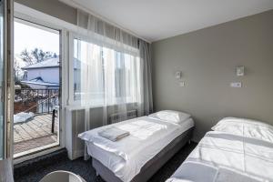 a bedroom with two beds and a large window at Willa Albatros Happy Hours in Gdańsk