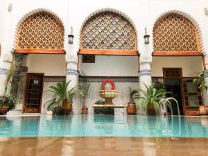 a swimming pool in a building with a fountain at Le Riad Palais d'hotes Suites & Spa Fes in Fez