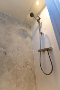 een douche in een badkamer met een glazen douchecabine bij Houseboats Lemmer in Lemmer