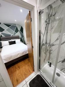a bedroom with a shower and a bed and a tub at 2 Southwell Road - Luxurious City Centre Apartments in Norwich