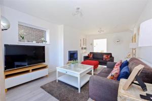 a living room with a couch and a tv at Stunning family home, walking distance to Herne Bay Beach! in Kent