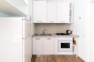 uma cozinha com armários brancos e um lavatório em Taaac Apartment - The House Of Travelers em Como
