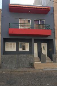 a blue building with a red balcony on it at Casa de Gá in Mindelo