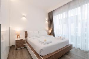 a bedroom with a large white bed with two towels on it at Purple Haze By AirCasa in Nairobi