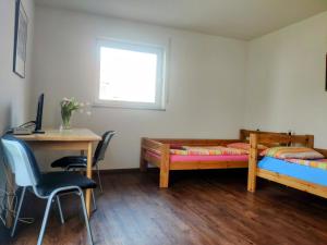 Habitación con 2 camas y escritorio con ordenador. en Doppelzimmer am Tuniberg Freiburg, en Freiburg im Breisgau