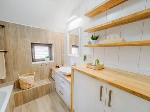 a bathroom with white cabinets and a sink in it at Malom és Kacsa in Tata