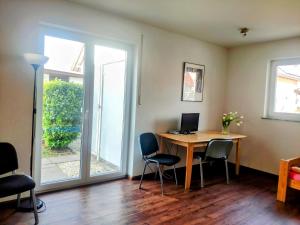 a room with a desk with a computer and chairs at Doppelzimmer am Tuniberg Freiburg in Freiburg im Breisgau