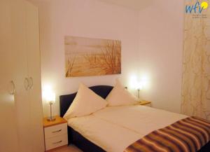 ヴァンガーオーゲにあるKaiserhof Ferienwohnung 4のベッドと壁に絵が飾られた寝室