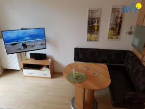 ヴァンガーオーゲにあるKaiserhof Ferienwohnung 4のソファとテーブルとテレビのあるリビングルーム