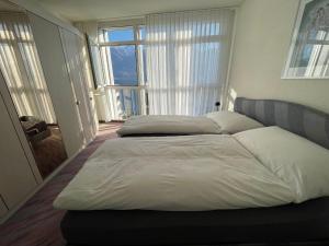 1 Schlafzimmer mit 2 Betten und einem großen Fenster in der Unterkunft Apartment Residenza Canto Sereno by Interhome in Minusio