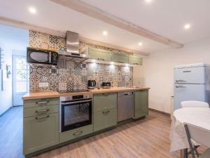 a kitchen with green cabinets and a stove top oven at Apartment Gigaro Plage by Interhome in La Croix-Valmer