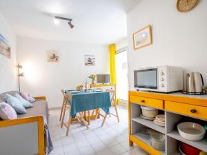 uma sala de estar com uma mesa e um micro-ondas em Apartment Jamaïc by Interhome em La Grande-Motte