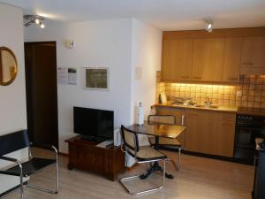 cocina con mesa y sillas y TV en Apartment Chalet Sunneblick by Interhome, en Grindelwald