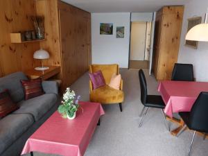 een woonkamer met een bank en een tafel en stoelen bij Apartment Utoring Acletta-25 by Interhome in Disentis