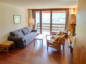 uma sala de estar com um sofá e uma mesa em Apartment Utoring Acletta-84 by Interhome em Disentis