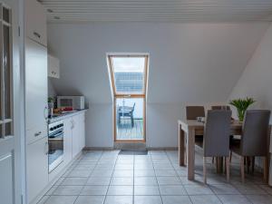 ノルトダイヒにあるApartment Norderney by Interhomeのキッチン、ダイニングルーム(テーブル、窓付)