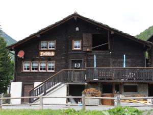 um grande edifício de madeira com uma escada em frente em Apartment Talblick by Interhome em Saas-Grund