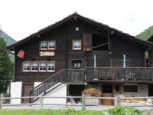 a large wooden building with a staircase in front of it at Apartment Talblick by Interhome in Saas-Grund